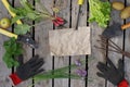 Kraft paper for your text surrounded by many garden hand tools and a summer harvest