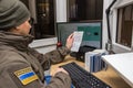 KRAKOVETS, UKRAINE - MARCH, 2019: Ukrainian female border guard in olive uniform checks for a fake traveler`s passport document