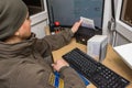 KRAKOVETS, UKRAINE - MARCH, 2019: Ukrainian female border guard in olive uniform scans a traveler`s passport document on the