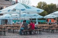 KRAKOW, POLAND, April 21, 2018, Many people sit at wooden portable tables in the square, in the background a number of toilets Royalty Free Stock Photo