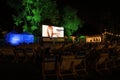 Krakow, Poland: An open cinema or movie projecting documentary for public at night with several people watching