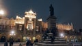 The statue of Adam Mickiewicz in front of the cloth hall during the nighttime