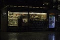Krakow, Poland - December 22, 2014: Rear view of a woman in winter jacket holding an umbrella in front of waffle shop during