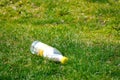 Krakow, Poland 10.03.2020: Discarded milk bottle on the green grass. Environmental pollution. Recycling of plastic waste. Plastic