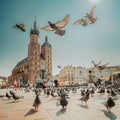 Krakow, Poland. Doves Birds Flying Near St. Mary's Basilica. Pigeons Flying Near Church Of Our Lady Assumed Into Heaven Royalty Free Stock Photo