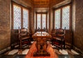 Krakow, Poland - Interior of a bowed window with stained glass, luxury chairs and a carved wooden table
