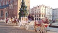 KRAKOW, POLAND - JANUARY, 14, 2017 Retro horse drawn carriages and Christmas decorated touristic Old town street