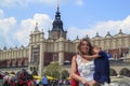 Krakow, Poland - June 11, 2018: Beautiful girl holding tired daughter in market square of Krakow. concept of traveling with kids