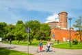 KRAKOW, POLAND - JUNE 08, 2016: Tourists walking near historical complex of Royal Wawel Castle with well seen Sandomierska tower o