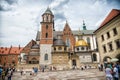 Krakow, Poland - June 04, 2017: Wawel cathedral with chapels on cloudy sky. People tourists on square infront catholic church. Arc