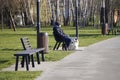Krakow, Poland 01.12.2019: a man in dark clothing sits on a bench in the Park on a bright Sunny autumn or spring day, a