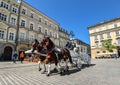 Horse carriage at main square in Krakow in a summer day, Poland. Two Horses In Old-fashioned Coach At Old Town Square Royalty Free Stock Photo