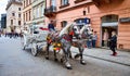 KRAKOW, POLAND - 10 of May, 2019: Horse carriage on the street of the old town in Krakow, Poland. Two horses in beautiful old-