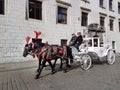 Krakow, Poland - 09.13.2017: Morning town after the rain. Bright sunny day. A horse-drawn carriage with a white coach drives touri