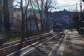 Krakow, Poland 16.12.2021: Sunny warm autumn weather in city, tram view in gallery with dried leaves on ground, grey trees. Urban