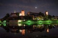 KRAKOW, POLAND: A view of Wawel Royal Castle in cracow at night from across the river Vistula illuminated during full moon with Royalty Free Stock Photo