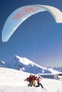 06.12.2019 Krasnaya Polyana, Russia. Paraglider takes off against the snow-capped mountains of the Caucasus.