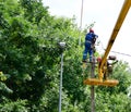 Electricians repair the wires on the pole with the help of a crane lifter.