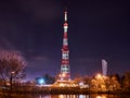 Krasnodar TV Tower at night, on which the searchlights shine and it changes colors. Red and white are primary colors