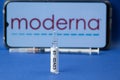 A medicine ampoule with the covid-19 label over the Moderna logo and syringe. Moderna is a company that produces a vaccine for the