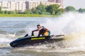 BRP Sea-Doo jet ski watercraft driver in action making turn and splashing at sunset on river