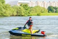 Happy smiling man on BRP Sea-Doo jet ski showing thumb up at sunset by river bank at countryside. Extreme sports and active summer Royalty Free Stock Photo