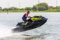 Jet ski watercraft driver in action making water splashes on summer sunny day at sunset on