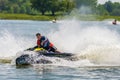 Jet ski watercraft driver in action making water splashes on summer sunny day at sunset on