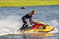 Krasnodar, Russia - July 25, 2020: Jet ski watercraft driver making water splashes on summer sunny day at sunset on river bank