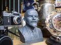Krasnodar, Russia, July 5, 2019: sculpture of Vladimir Lenin. An old Soviet Zenit-E camera, a watch, and a samovar