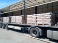 Unloading bags of cement from a truck with a forklift