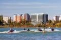 Jet ski racers drive watercrafts toward start point on townscape background while racing at Royalty Free Stock Photo