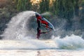 Jet ski sportsman turning freestyle somersault and splashing in evening during South Russian