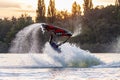 Jet ski sportsman turning somersault and splashing in evening during South Russian Aquabike