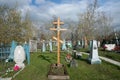 A wooden cross among the graves at the Troitskoye cemetery 1842 of the city of Krasnoyarsk, in the spring.