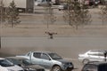 Unmanned aerial vehicle - a quad copter with a camera and a video broadcast flies over the parking of cars against the background