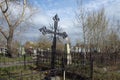 Iron forged cross banked among the graves at Troitskoye cemetery 1842 in the city of Krasnoyarsk, in the spring. Royalty Free Stock Photo