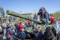 Children play on the tank on the central square of Krasnoyarsk among the exhibition of artillery big guns, during the celebration