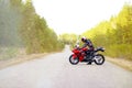 KRASNOYARSK, RUSSIA - April 27, 2018: Beautiful motorcyclist in full gear and helmet on a red and black Honda 2005 CBR 600 RR Royalty Free Stock Photo