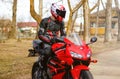 KRASNOYARSK, RUSSIA - April 21, 2018: Beautiful motorcyclist in full gear and helmet on a red and black Honda 2005 CBR 600 RR Royalty Free Stock Photo