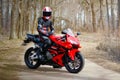 KRASNOYARSK, RUSSIA - April 21, 2018: Beautiful motorcyclist in full gear and helmet on a red and black Honda 2005 CBR 600 RR PC3 Royalty Free Stock Photo