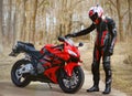 KRASNOYARSK, RUSSIA - April 21, 2018: Beautiful motorcyclist in full gear and helmet on a red and black Honda 2005 CBR 600 RR Royalty Free Stock Photo