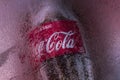 Krasnoyarsk, Russia, August 16, 2020: a Bottle of Coca Cola frozen in a block of ice. Label and logo close-up