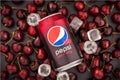 Krasnoyarsk, Russia - 1 July 2019: Aluminium can of the Pepsi Wild Cherry over dark background. Beautiful cherry berries and ice