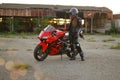 KRASNOYARSK, RUSSIA - June 23, 2018: Beautiful girl motorcyclist in full gear and helmet on a red and black Honda 2005 CBR 600 RR