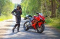 KRASNOYARSK, RUSSIA - June 23, 2018: Beautiful girl motorcyclist in full gear and helmet on a red and black Honda 2005 CBR 600 RR