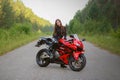 KRASNOYARSK, RUSSIA - June 28, 2018: Beautiful girl motorcyclist in full gear and helmet on a red and black Honda 2005 CBR 600 RR