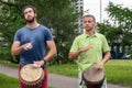 Krasnoyarsk, Russia, June 30, 2019: two European men play African drums in a public Park in the summer Royalty Free Stock Photo