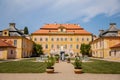 Krasny Dvur Chateau, North Bohemia, Czech Republic, 19 June 2021: Baroque yellow castle with stairs, front yard with green lawn