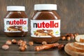 Two jars of nutella on a wooden background.